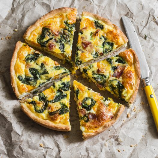 Vegetable and turkey quiche on a paper background.