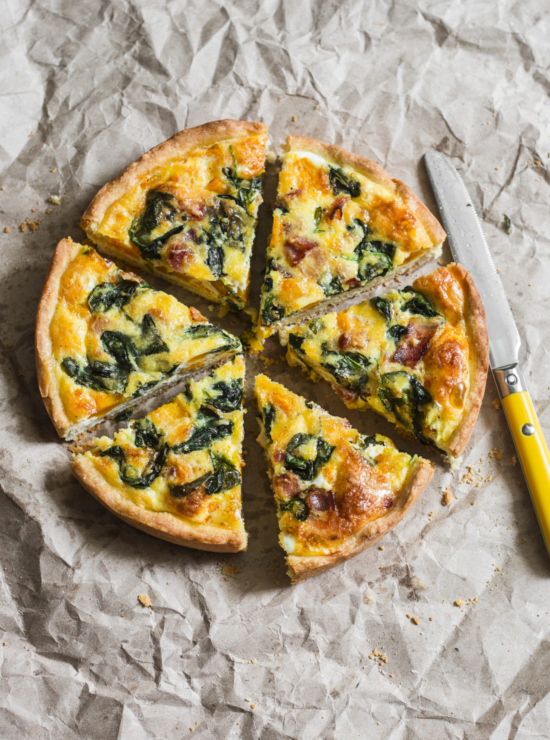 Vegetable and turkey quiche on a paper background.